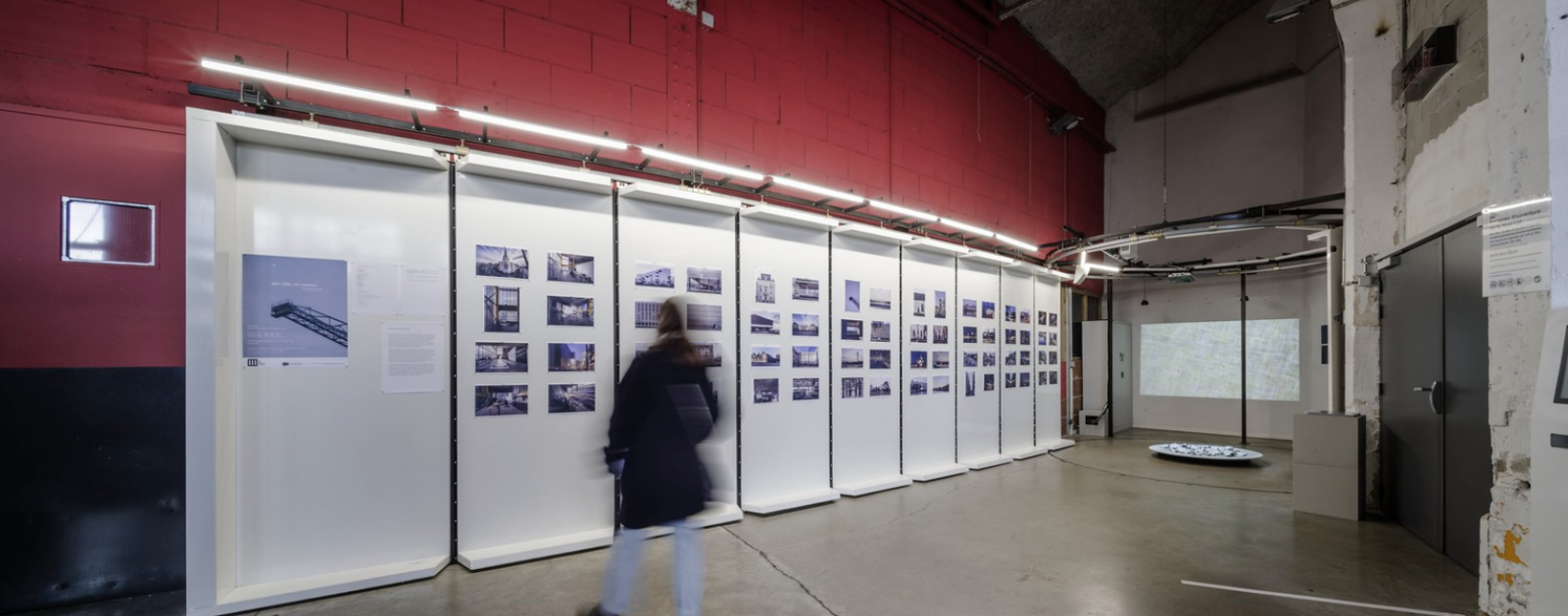 Visiteur devant une exposition photographique dans une galerie