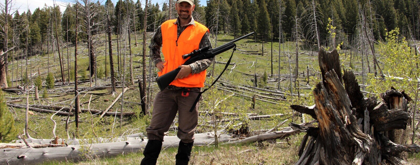 Chasseur marchant en forêt avec son arme orientée vers le sol, image d’illustration