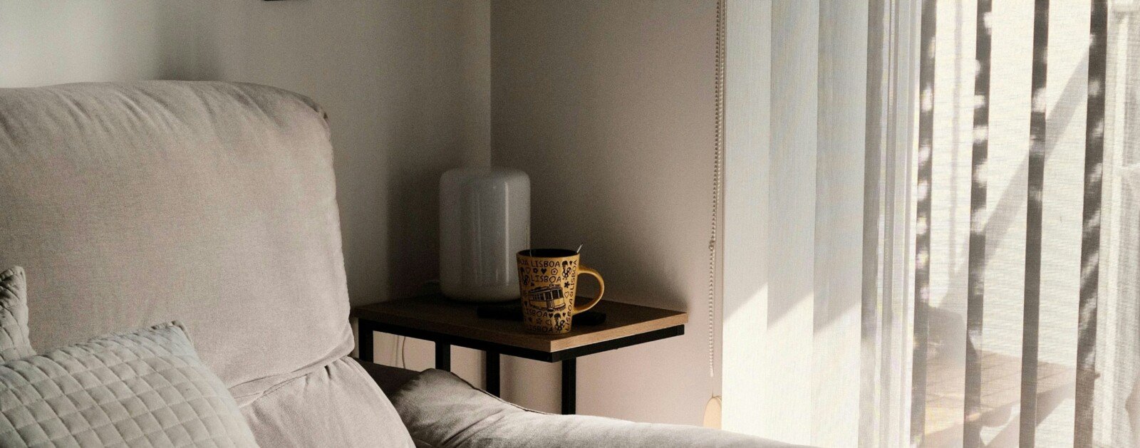 Salon lumineux avec un canapé près d'une fenêtre, photographie illustrative d'une annonce immobilière