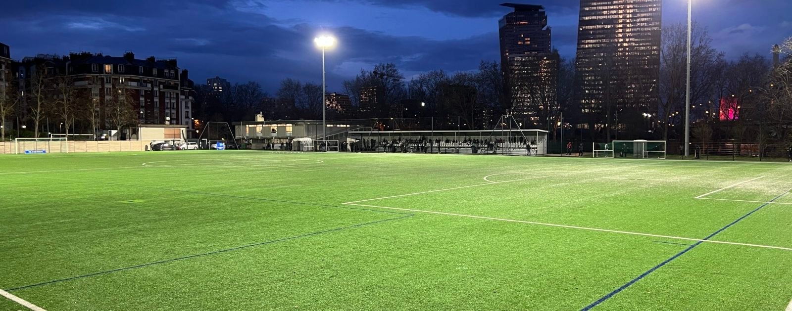 Match de football sur une pelouse sous éclairage