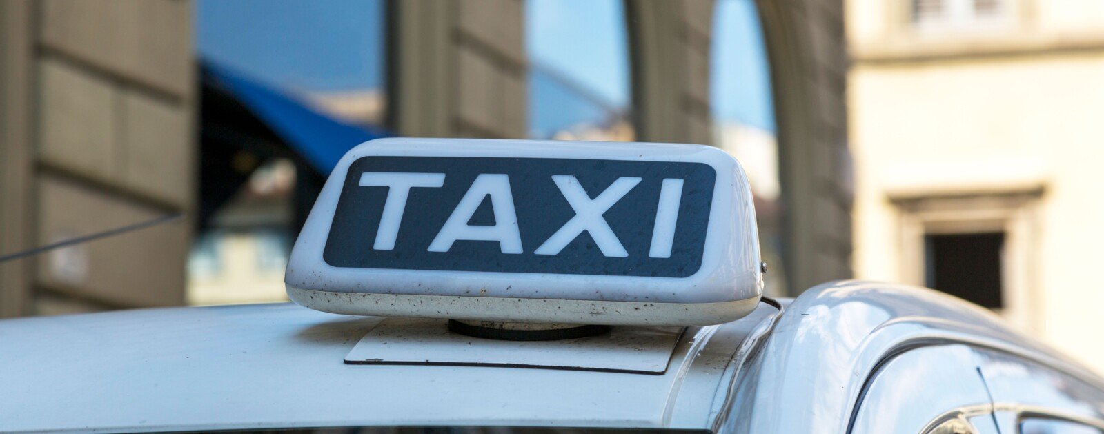 Lumineux TAXI sur le toit d’un véhicule dans une rue urbaine