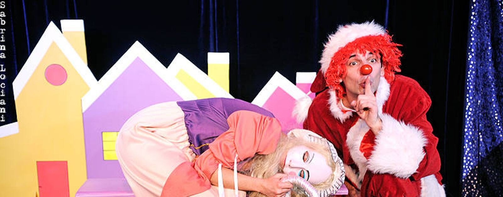 Gabilolo en costume rouge sur scène, aux côtés d'une fée, dans La hotte du Père Noël au Théâtre de Jeanne