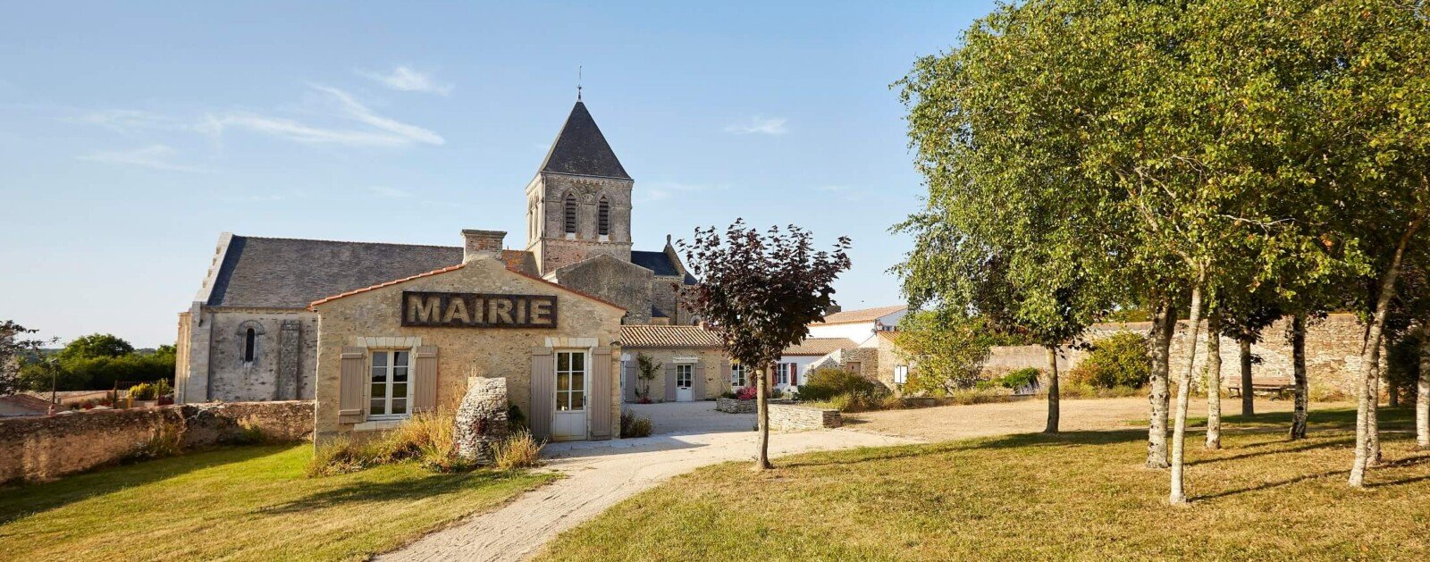 Vue d’archives de la mairie, du clocher et des jardins de La Chaize-Giraud, utilisée pour illustrer la vie du centre-bourg.