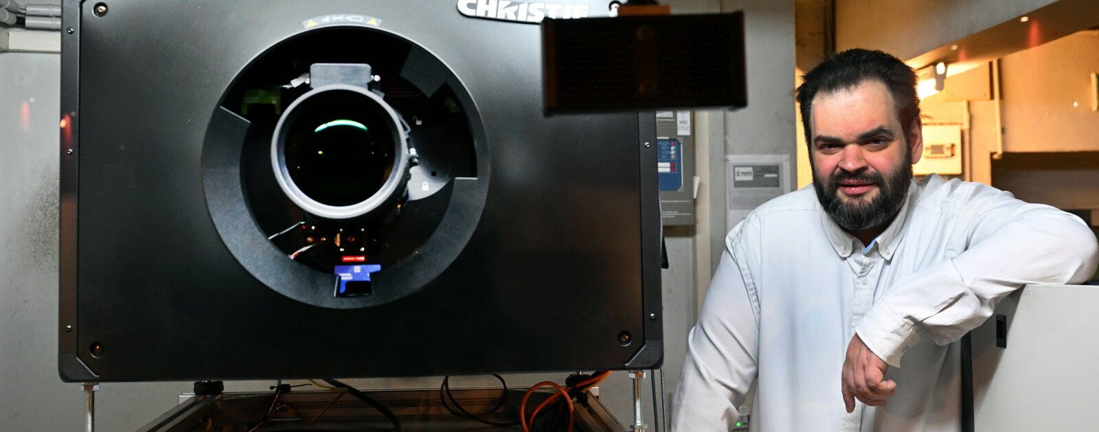 Un projectionniste auprès d'un projecteur laser Christie dans une cabine de cinéma