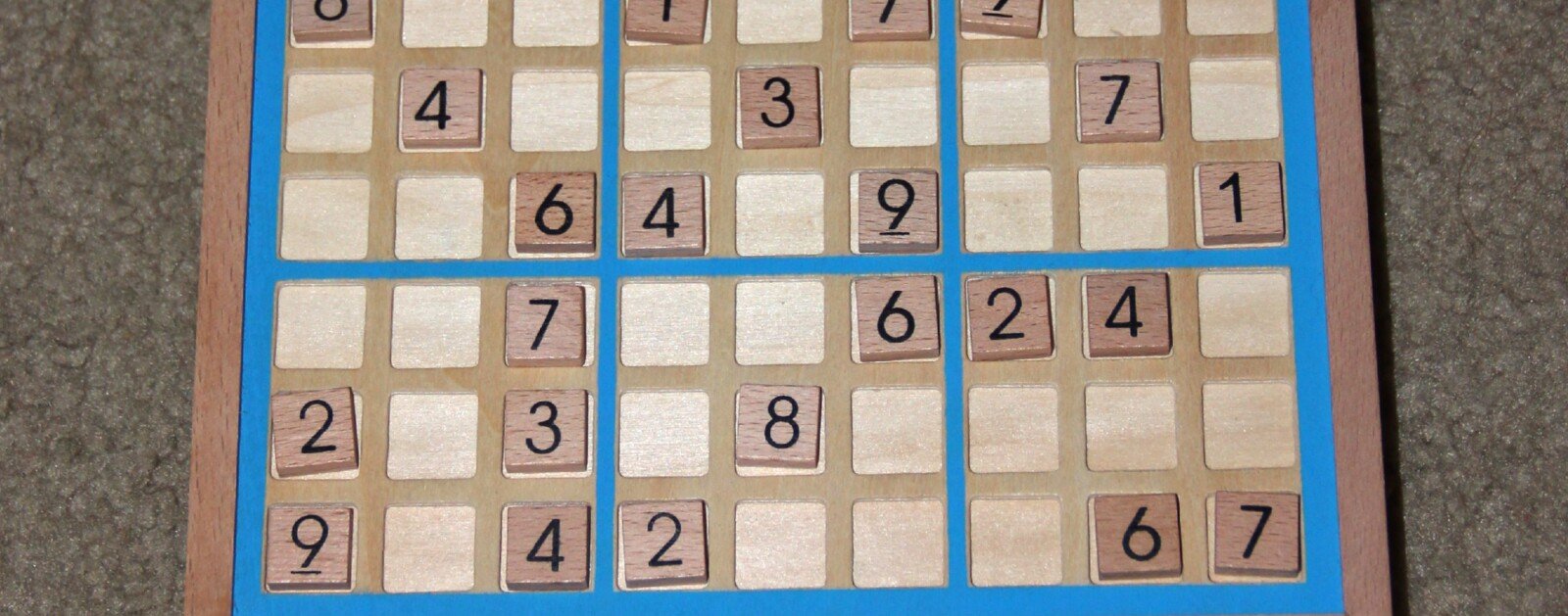 Plateau de sudoku en bois avec des chiffres, photographie illustrative des jeux de logique
