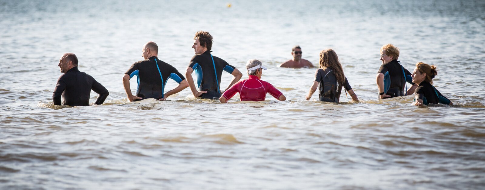 Participants à une activité collective de baignade sur la côte de Jade, photo d'illustration