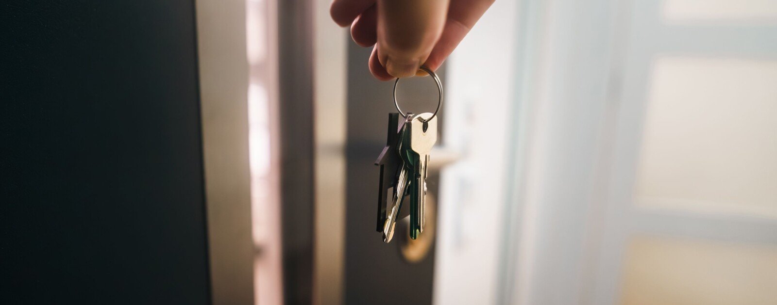 Main tenant des clés à l’entrée d’un logement