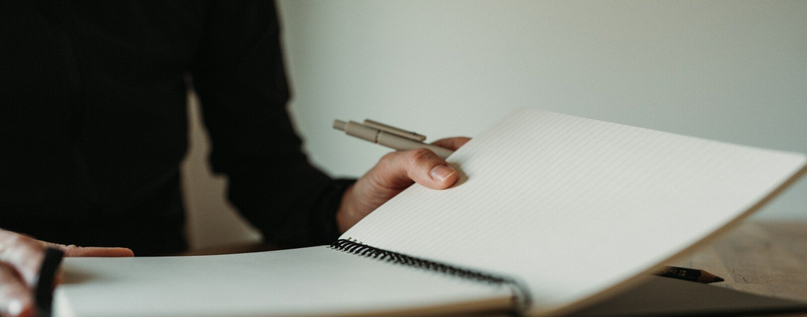 Personne écrivant dans un carnet à une table, photo d'illustration d'un atelier d'écriture