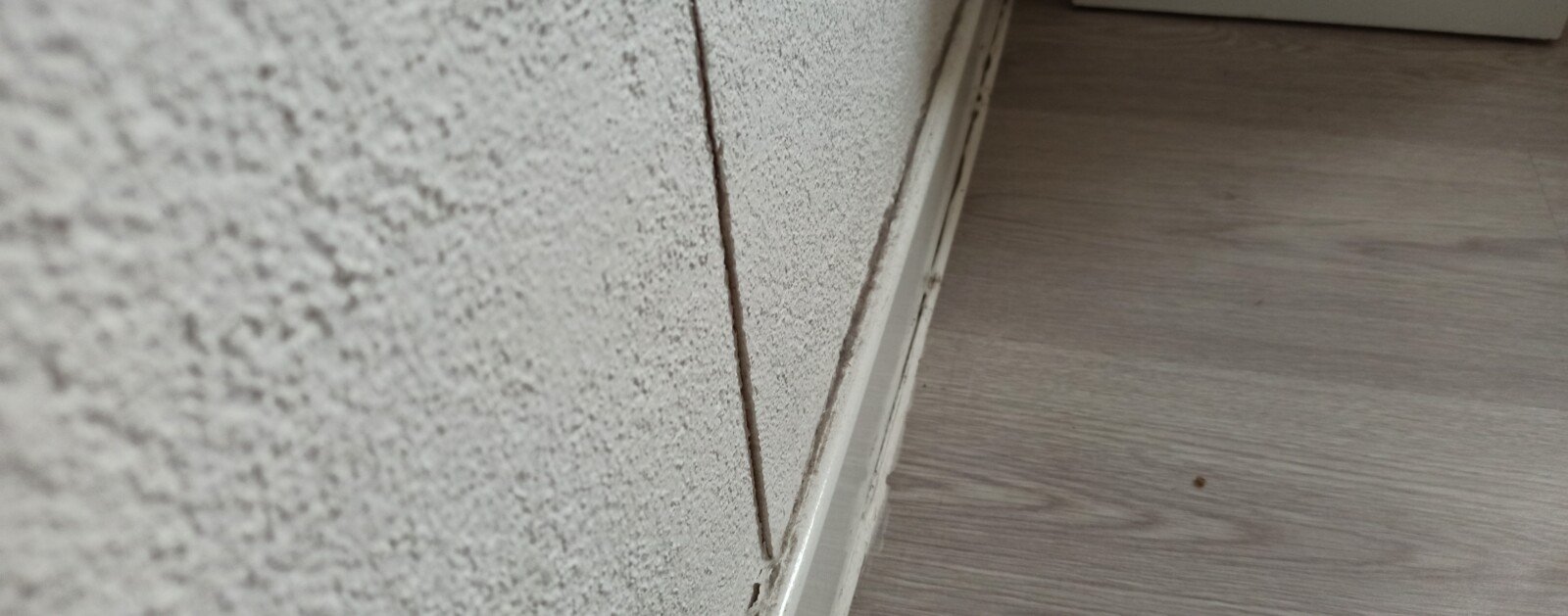 Fissure sur le mur d'un bâtiment, photographie réelle illustrant les désordres évoqués
