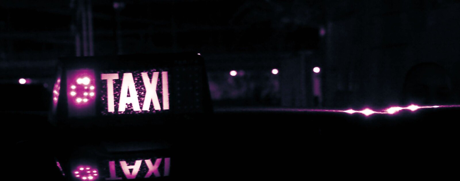 Lumineux TAXI éclairé de nuit sur le toit d’un véhicule