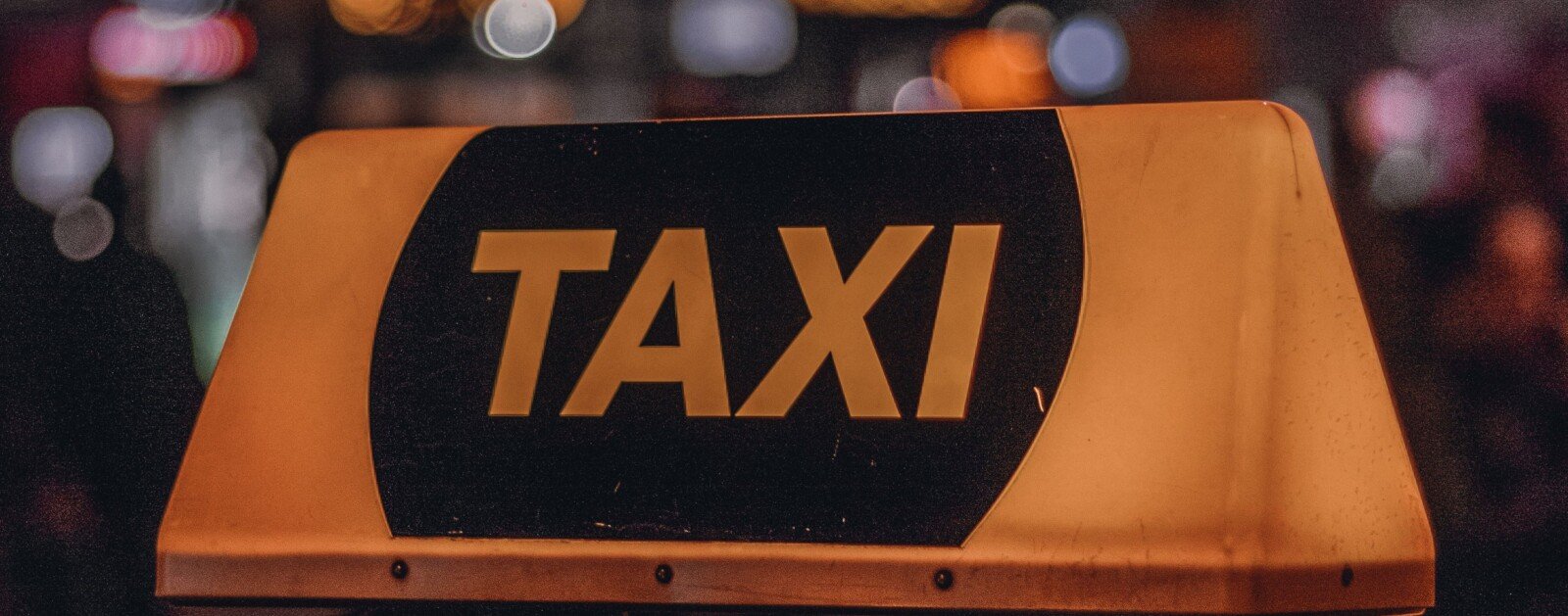 Lumineux TAXI jaune sur le toit d’un véhicule de nuit