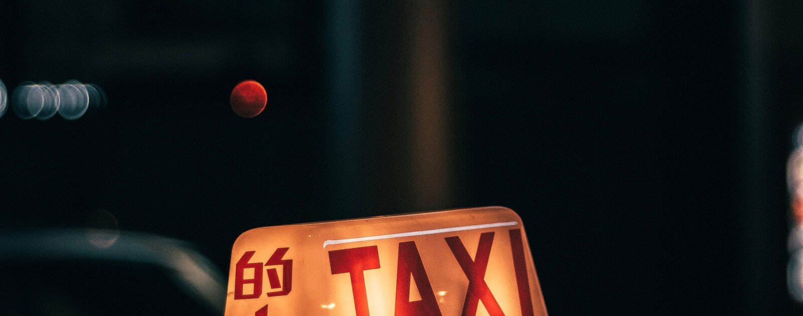Lumineux TAXI sur le toit d’un véhicule dans une rue urbaine